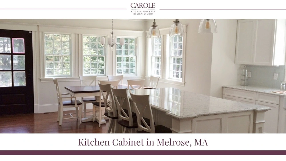 Bright white kitchen featuring a spacious marble island with seating and custom cabinets